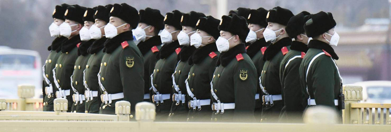Police officers wearing masks stand guard at Tiananmen Square in Beijing.