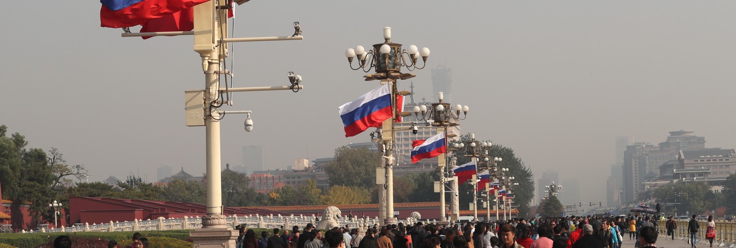 Chinese and Russian national flags flutter on lampposts in front of the Tian'anmen Rostrum
