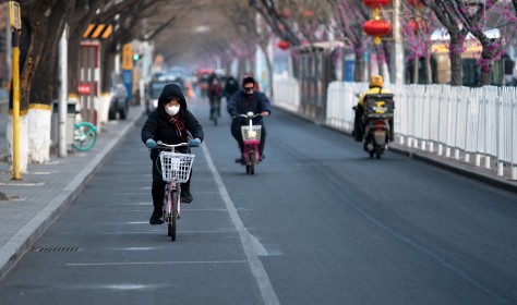People riding bicycles in a street in Beijing.