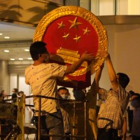 Workers place a national emblem outside the Metropark Hotel Causeway Bay
