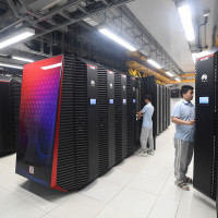 Engineers work on the server cabinets in a new section of Wuhan Supercomputing Center in Wuhan.