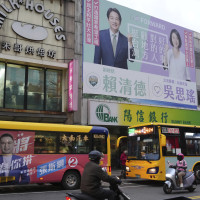 Candidates' posters of the Taiwanese presidential election are hung on a building wall in Taipei on Dec. 21, 2023.