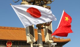 Chinese and Japanese national flags flutter on the lamppost in front of the Tian'anmen Rostrum