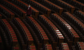 A hostess gives a final check on the reports placed on tables ahead of the closing session of the National People's Congress (NPC) at the Great Hall of the People in Beijing, Monday, March 11, 2024.