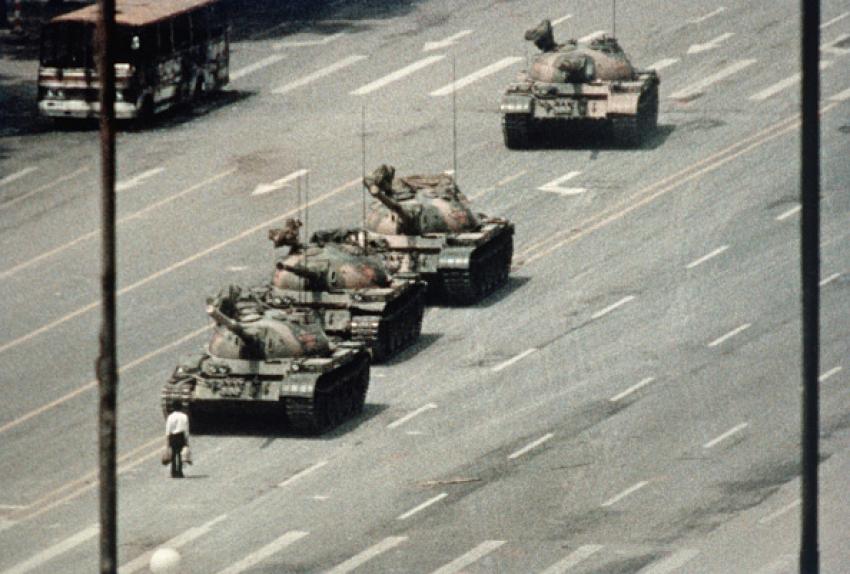 Man standing in front of a column of tanks leaving Tiananmen Square on June 5, 1989