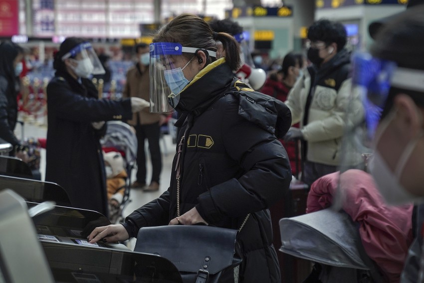 Woman with face mask and shield at South Train Station in Beijing, Jan 2021